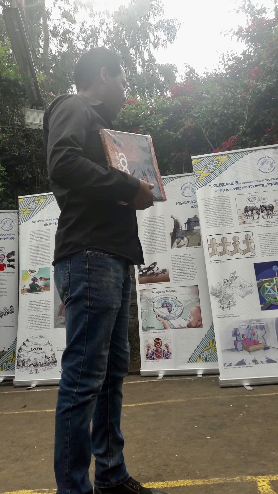 Elias Areda in front of the exhibition “Cartooning for Peace and Democracy”