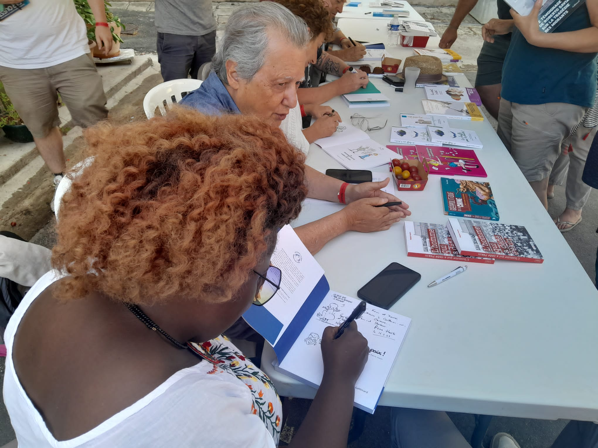 Signing session with the cartoonists and Pierre Haski around the book “Fichez-nous la paix!” – Celeste (Kenya) and Pierre Haski