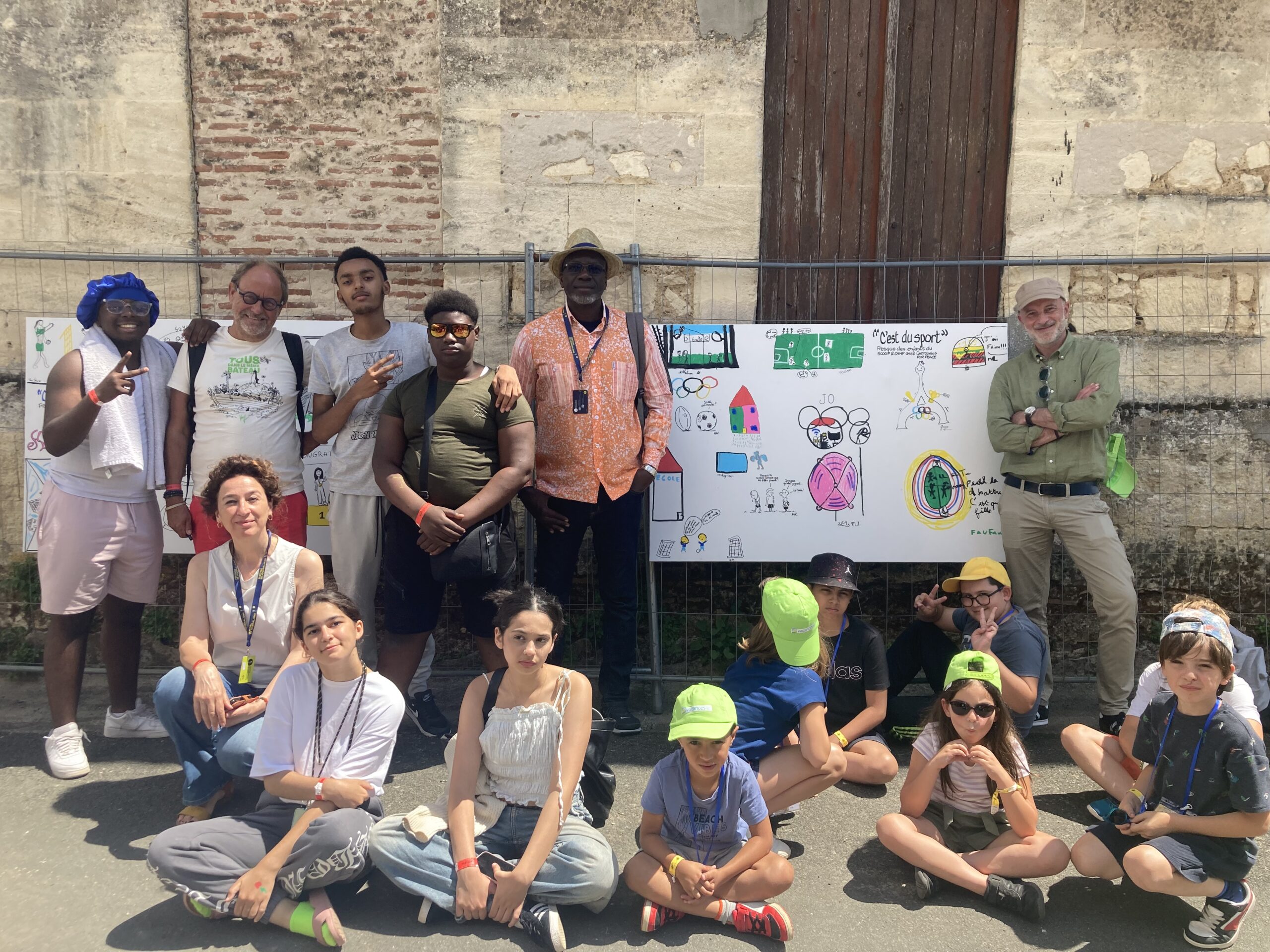 Kroll (Belgique), Nardi (Italie), Zohoré (Côté d’Ivoire) et Kak (France) avec les jeunes participants à la fresque collective