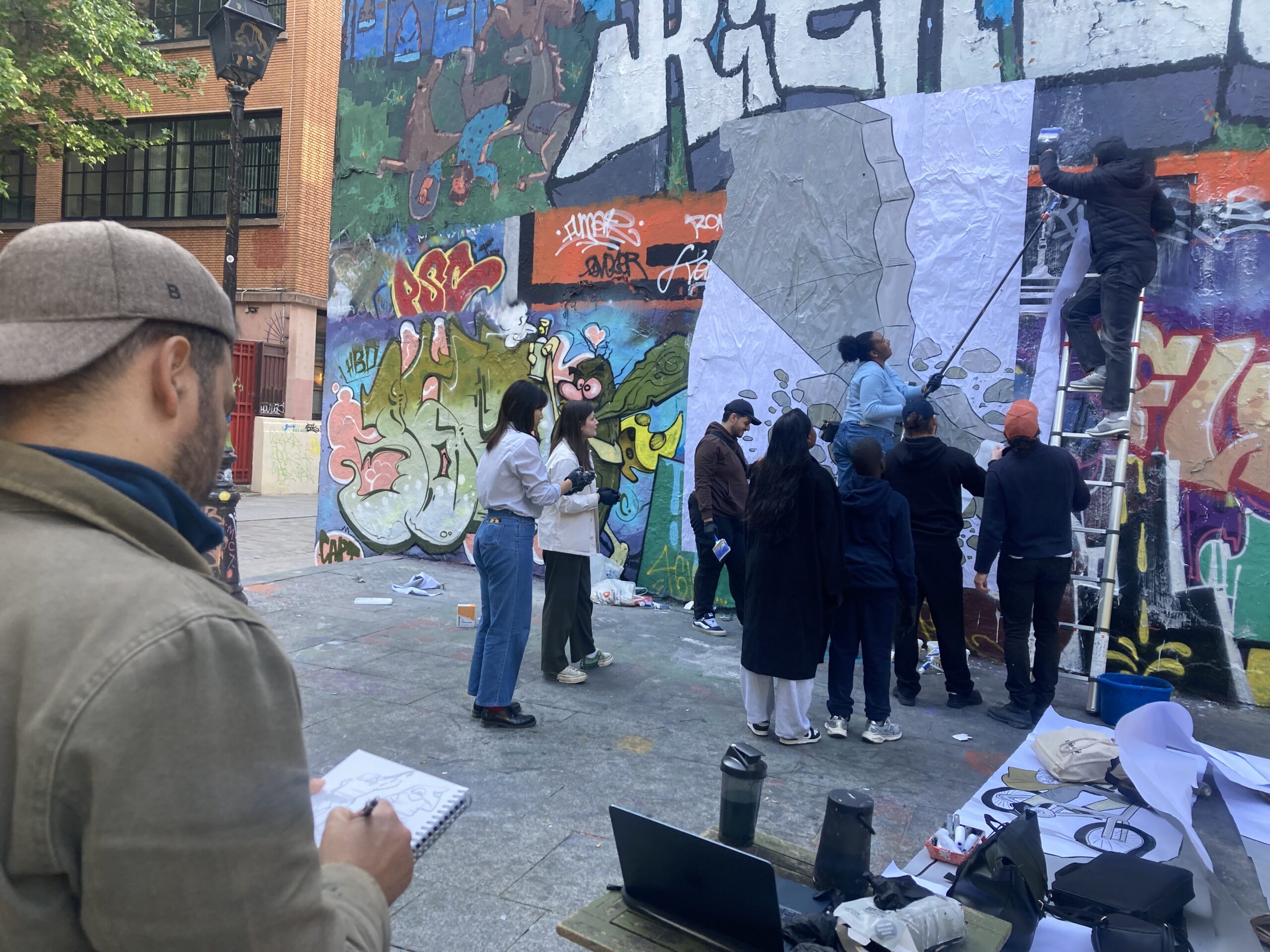 Wimar (Cuba) croquant en dessin la fresque street-art, le 6 mai 2025